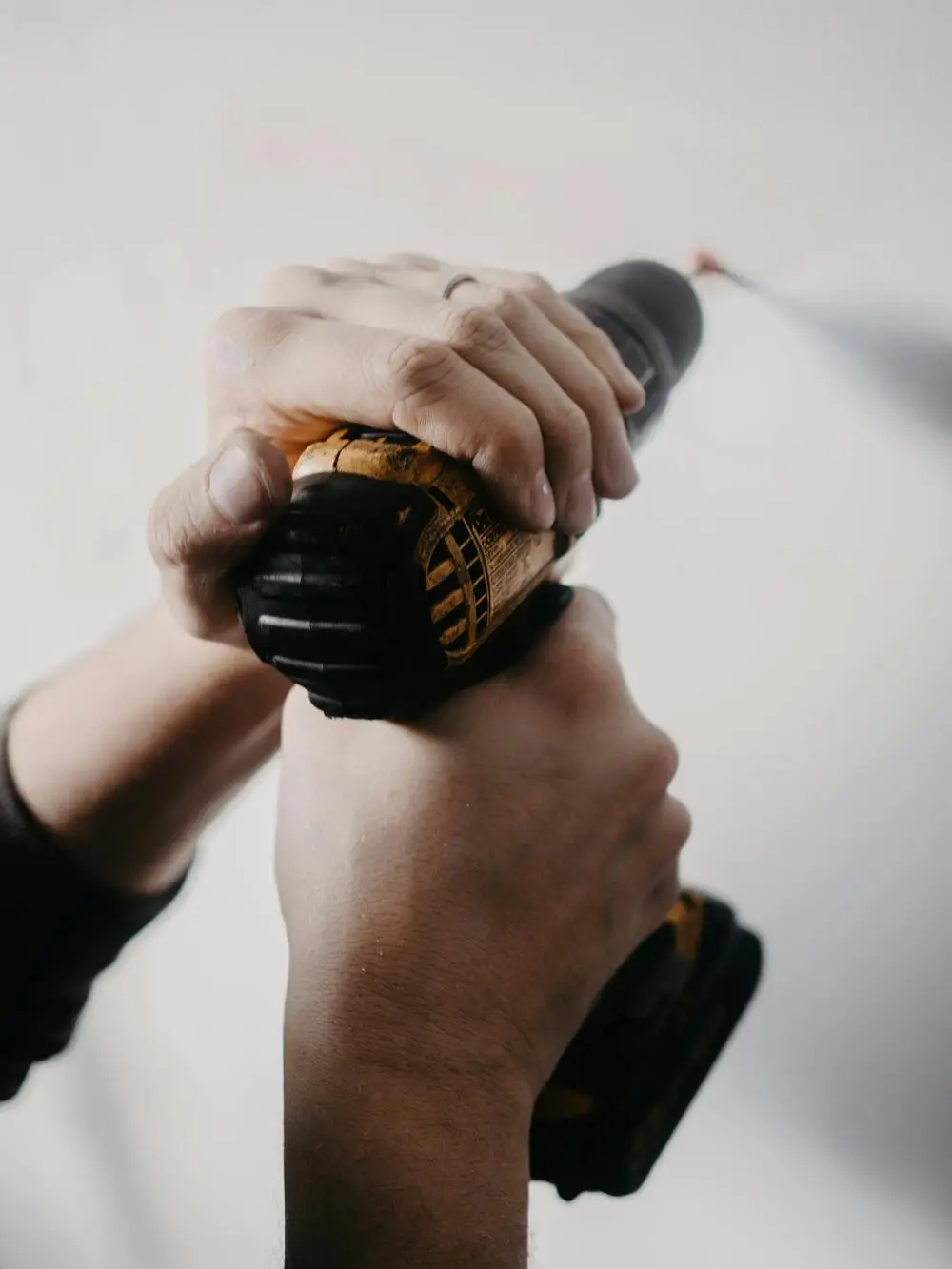 hands holding power drill